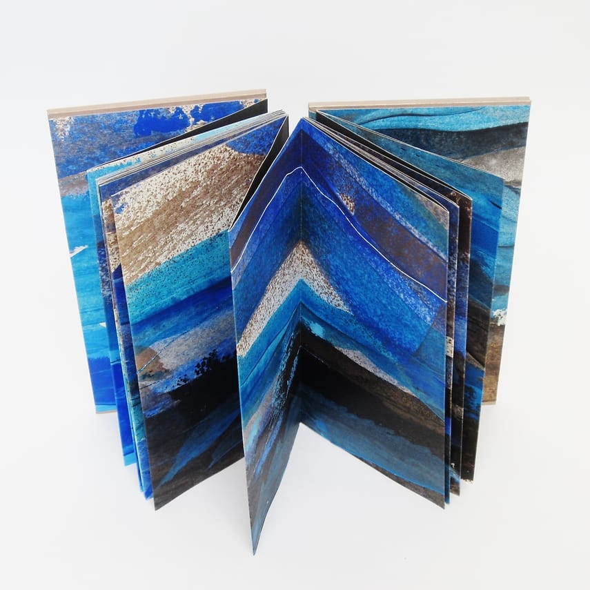 Leporello schilderij Geschilderd boekobject gemaakt van lange smalle schildering op papier waarna leporello gevouwen en als boek afgewerkt. Vele kleuren maar vooral koper, blauw en zwart.