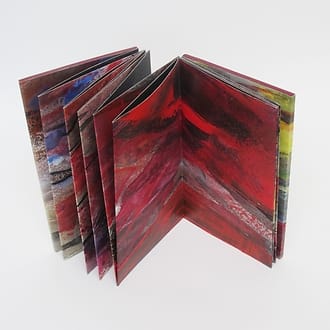 Geschilderd boekobject gemaakt van lange smalle schildering op papier waarna leporello gevouwen en als boek afgewerkt. Vele kleuren maar vooral zilver en diverse tinten rood.