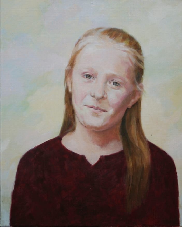 Portret van glimlachend meisje met loshangend rood haar.